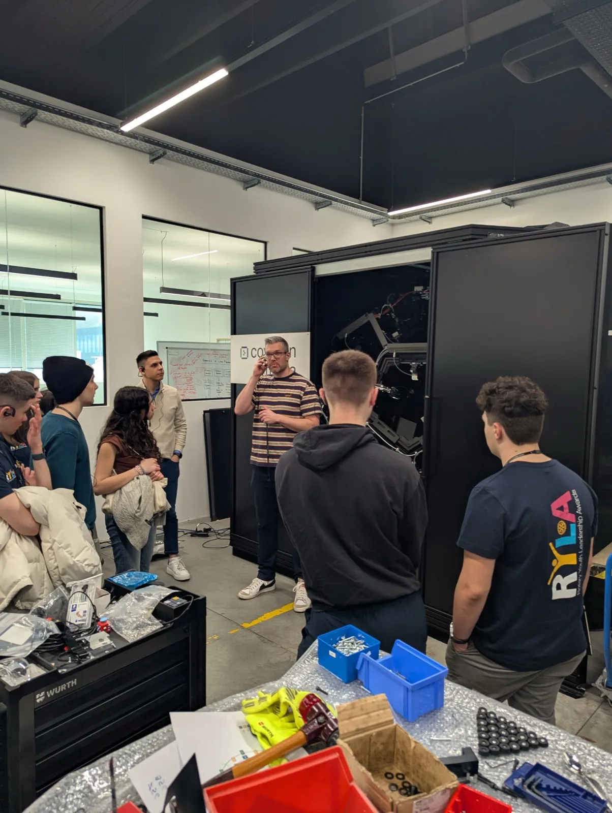 Participants wearing tour headsets following a guide through a modern showroom with illuminated display panels