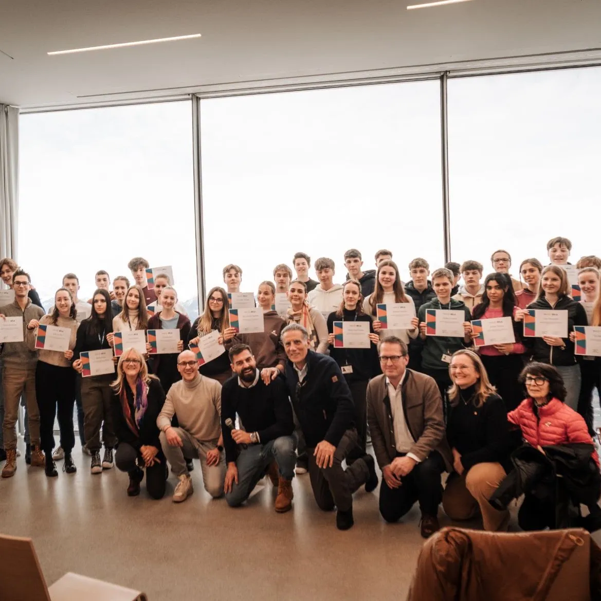 Participants holding their certificates at the end of the 2024 camp, with the organisers kneeling in front